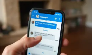Palec dotyka ekranu telefonu, pokazując opcję "Delete" w aplikacji Messenger. Dowiedz się, jak usunąć stare wiadomości z Messengera u odbiorcy.