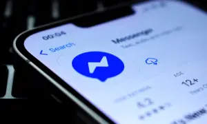 Szukasz sposobu, jak sprawdzić czy ktoś jest dostępny na Messengerze nie mając go w znajomych? Ekran telefonu z ikoną Messengera i opcją wyszukiwania.