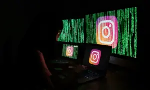 Osoba przy komputerze próbuje dowiedzieć się, jak odblokować konto na Instagramie. Na ekranach widnieje logo Instagrama na tle kodu.