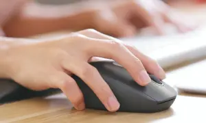 Dłoń steruje myszką bezprzewodową. Dowiedz się, jak podłączyć myszkę bezprzewodową do laptopa bez USB, korzystając z Bluetooth.