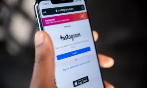 Ktoś trzyma smartfon z otwartą stroną logowania do Instagrama. Czy ktoś widzi, jak oglądam relacje na Instagramie?
