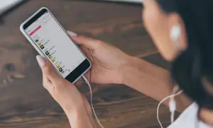 Kobieta wybiera muzykę na telefonie, by dowiedzieć się, jak dodać muzykę do relacji na Instagramie.