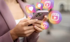 Dłonie trzymające telefon, nad którym unoszą się ikony Instagrama. Szukasz sposobu, jak odzyskać konto na Instagramie?