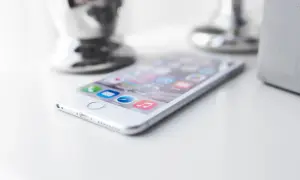 Biały iPhone na białym blacie. Zastanawiasz się, jak zmniejszyć pamięć Messengera? Oto wskazówka.