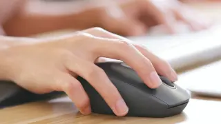 Dłoń steruje myszką bezprzewodową. Dowiedz się, jak podłączyć myszkę bezprzewodową do laptopa bez USB, korzystając z Bluetooth.