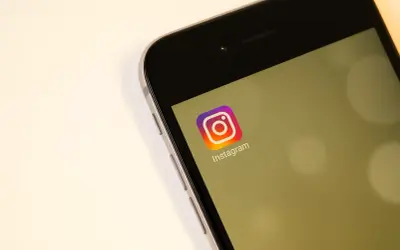 Na ekranie telefonu widoczny jest symbol Instagrama. Zastanawiasz się, czy na IG widać kto odwiedza profil?