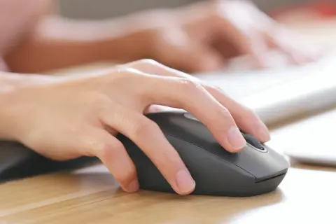 Dłoń steruje myszką bezprzewodową. Dowiedz się, jak podłączyć myszkę bezprzewodową do laptopa bez USB, korzystając z Bluetooth.