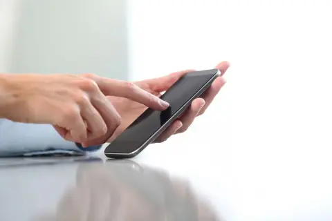 Dłonie trzymające smartfon, pokazujące jak doładować telefon w Play na kartę.