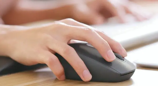 Dłoń steruje myszką bezprzewodową. Dowiedz się, jak podłączyć myszkę bezprzewodową do laptopa bez USB, korzystając z Bluetooth.