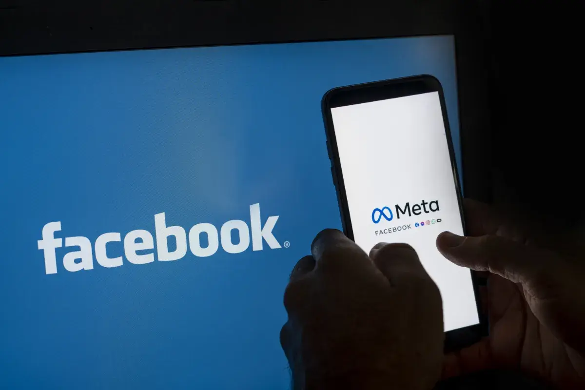 Chcesz wiedzieć, jak zablokować konto na Facebooku? Na ekranie telefonu widać logo Meta i Facebooka.