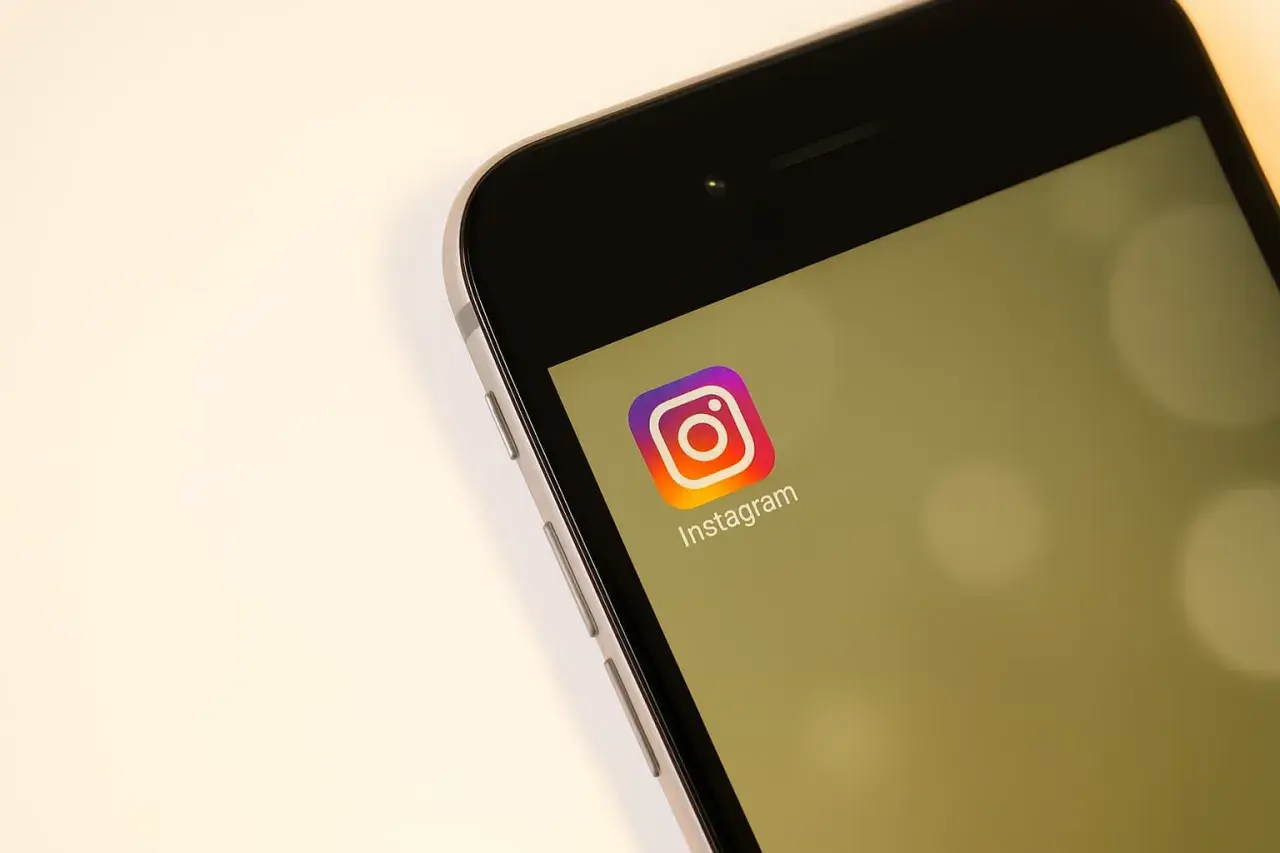 Na ekranie telefonu widoczny jest symbol Instagrama. Zastanawiasz się, czy na IG widać kto odwiedza profil?