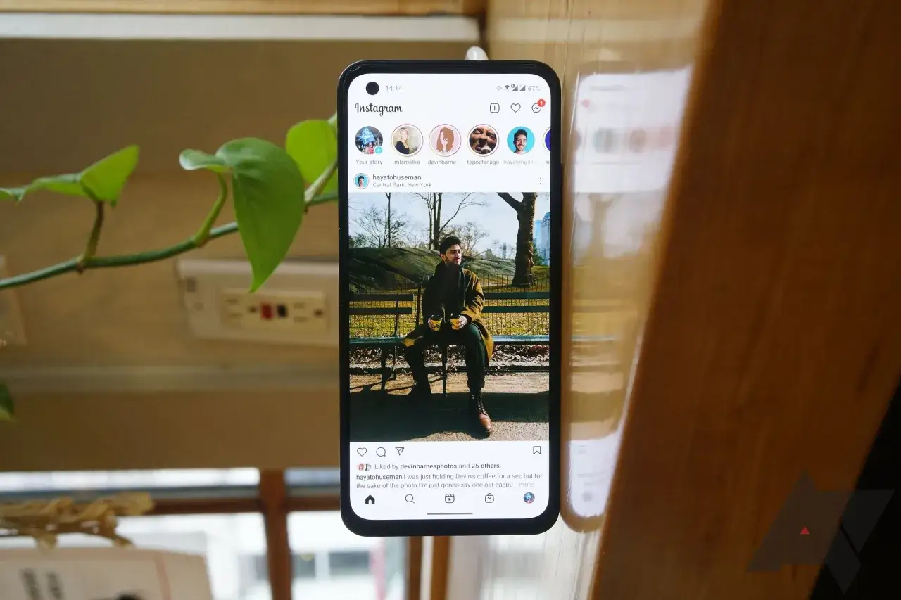 Telefon z aplikacją Instagram, gdzie mężczyzna siedzi na ławce z kawą. Szukasz darmowe like na Instagramie aplikacja?