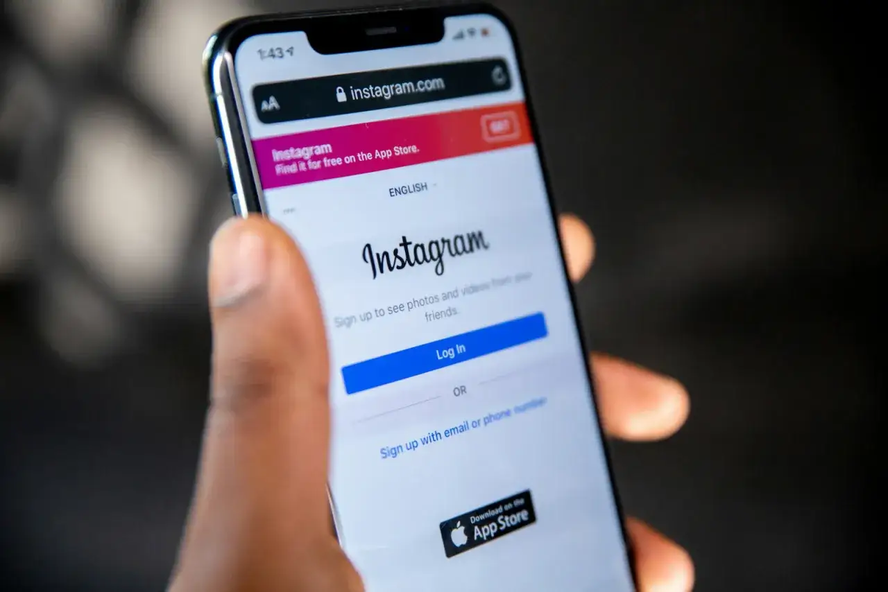Dłoń trzyma smartfon z ekranem logowania do Instagrama. Może to być pierwszy krok do usunięcia konta na Instagramie.