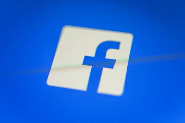 Logo Facebooka na niebieskim tle.