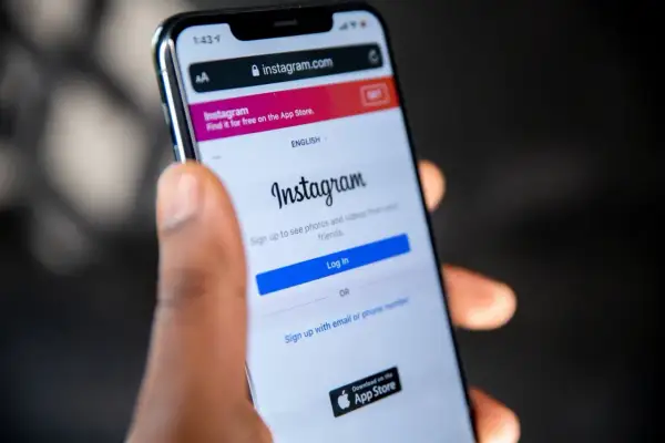 Dłoń trzyma smartfon z ekranem logowania Instagram. Dowiedz się, jak odzyskać skradzione konto na Instagramie, gdy widzisz ten ekran.