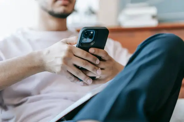 Mężczyzna z telefonem w dłoniach. Zastanawia się, jak sprawdzić czy ktoś mnie zablokował na Messengerze.