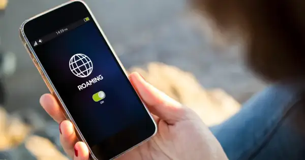Telefon pokazuje ikonę globu i napis "ROAMING" z włączonym przełącznikiem. To oznacza, że funkcja roamingu jest aktywna.