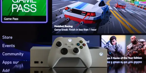 Biały kontroler Xbox i konsola na tle ekranu z menu Game Pass i grami. Dowiedz się, jak pobierać gry na Xbox, korzystając ze sklepu i Game Pass.